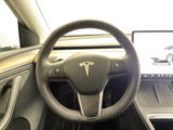 the steering wheel of a car with a laptop in the background