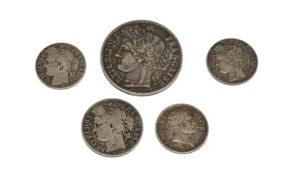 six types différents de pièces d'argent sur une surface blanche