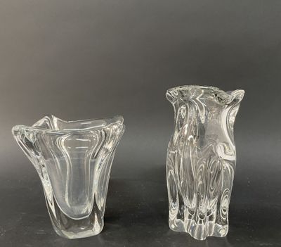 deux vases en verre transparent posés sur une surface noire avec un fond gris
