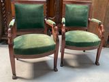 une paire de chaises en velours vert dans une pièce où se trouve une armoire en bois