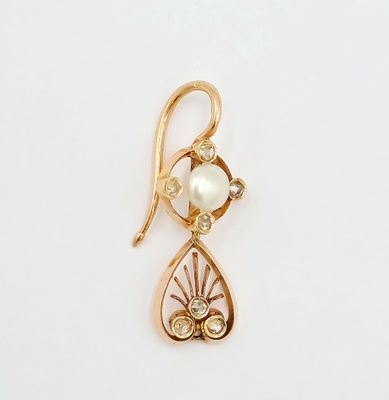 un gros plan d'un pendentif en or et perles sur fond blanc