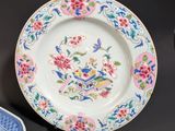 a plate with a floral design on it next to a plate with a flower design on it