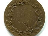 une vieille médaille en bronze ornée d'une couronne sur le recto