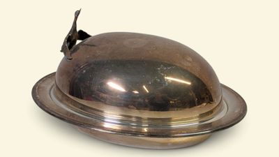 une assiette en argent surmontée d'un couvercle bombé