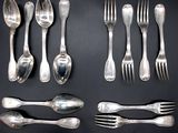 a lot of silver spoons and forks laid out on a table
