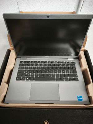 un ordinateur portable ouvert, posé dans une boîte sur une table