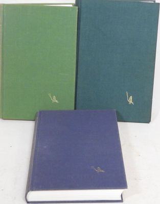 three books are lined up in a row on a white surface