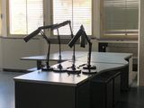 un bureau sur lequel se trouvent deux lampes, dans une pièce vide