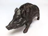 a small black pig figurine sitting on a white surface