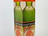 two bottles of orange juice sitting on top of a cardboard box