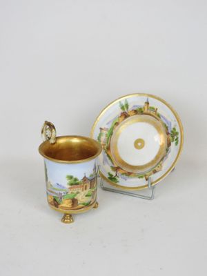 a close up of a cup and saucer on a white surface