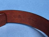 a leather belt with a metal buckle on a blue surface