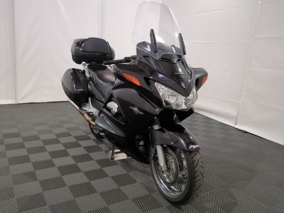 une moto noire garée sur un sol à damier