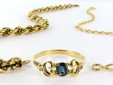 un gros plan d'une bague et d'une chaîne sur une surface blanche