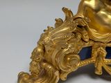 a gold and blue clock with a statue on it