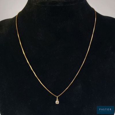 un collier en or orné d'un diamant autour du cou d'un mannequin