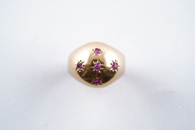 une image représentant une bague en or sertie de pierres roses sur un fond blanc
