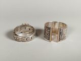 two silver rings sitting on top of each other on a table