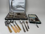 un coffret contenant de l'argenterie et des cuillères, posé sur une table
