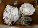 many plates and bowls in a box on the floor