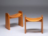 two wooden stools sitting side by side on a white surface