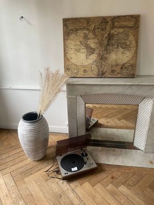 a picture of a record player and a vase on the floor
