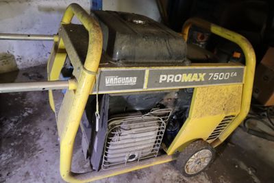 un générateur portable jaune et noir posé dans un garage, contre un mur