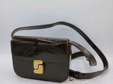un sac à main noir orné d'une boucle dorée sur le devant