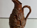 a brown vase that is sitting on a glass table