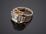 a close up of a gold ring with two diamonds on a black surface