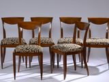 quatre chaises en bois dont les assises sont recouvertes d'un tissu à motif zébré, dans une pièce