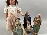 several dolls of different sizes and shapes are posed together