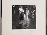 photographie en noir et blanc d'une rue où l'on voit une personne qui s'y promène