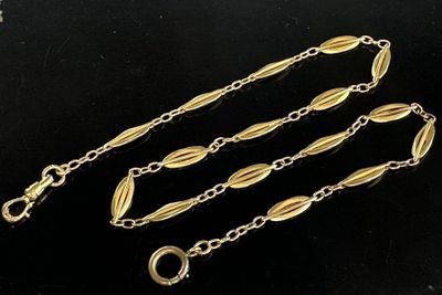 a close up of a gold chain on a black surface