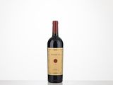 a bottle of wine sitting on top of a table next to a white wall