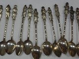 six silver spoons are lined up in a row on a table