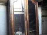 a large wooden cabinet with a mirror on top of it