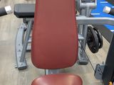a gym machine with a red seat in the middle of the room
