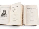 two open books on a white surface with a picture of a man in a coat