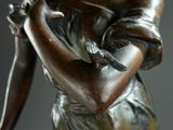 bronze statue of a woman holding a bird in her hand