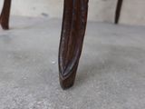 a close up view of a wooden chair with a curved seat