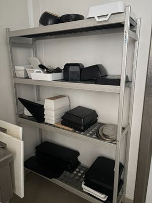 une étagère métallique sur laquelle sont disposés de nombreux appareils électroniques de toutes sortes