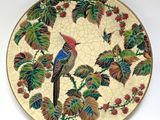 a decorative plate with a bird on a branch of a tree