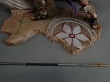 a figurine of a woman with a sword on a rock