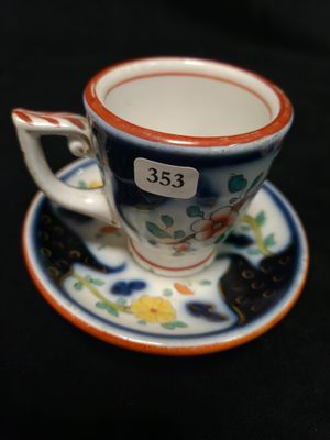 une petite tasse et une soucoupe ornées d'un chat