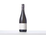a bottle of wine sitting on top of a table next to a white wall