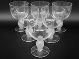 six verres à vin transparents posés sur une table noire