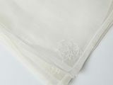 a close up of a white cloth with a monogram on it