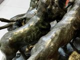 statue représentant un groupe de chiens courant sur un rocher dans un hall d'entrée