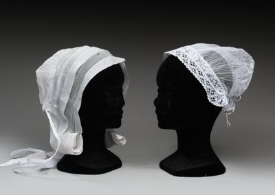 une paire de têtes de mannequins noires recouvertes de voiles blancs